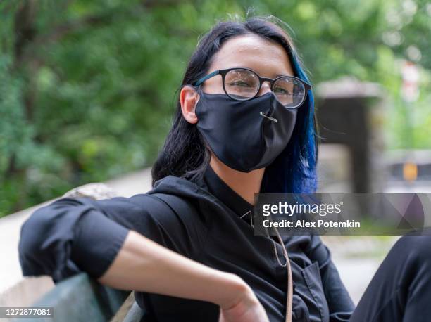 portrait of the pretty smiling 17-years-old teenage girl with the dyed hair wearing eyeglasses and a protective mask. - alex potemkin coronavirus stock pictures, royalty-free photos & images