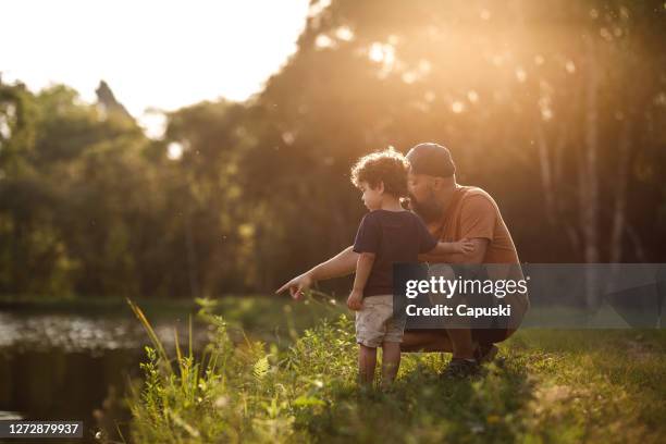 padre mostrando lago a su hijo - naturaleza fotografías e imágenes de stock