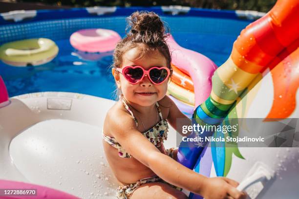 cute girl in a swimming pool - inflatable pool toys imagens e fotografias de stock