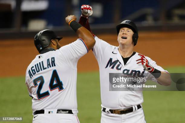 Garrett Cooper of the Miami Marlins celebrates with Jesus Aguilar after hitting a 2-run home run during the first inning off Mike Kickham of the...
