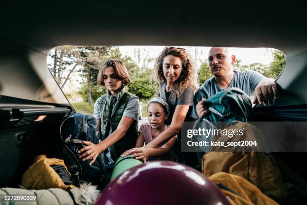 família caucasiana carregando o carro para uma viagem ao lago. - equipamento esportivo - fotografias e filmes do acervo