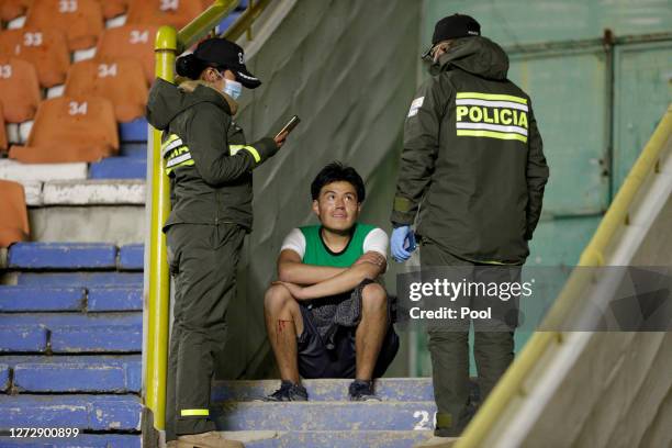 Fan of Bolivar who managed to get into the stadium speaks to police officers during a group B match of Copa CONMEBOL Libertadores 2020 between...