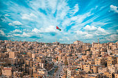 Jordan flag in Amman, landscape view of cloudy sky background