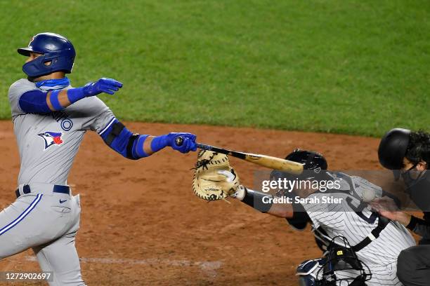 Umpire John Tumpane is hit by the baseball as Lourdes Gurriel Jr. #13 of the Toronto Blue Jays follows through and Kyle Higashioka of the New York...