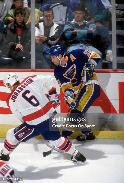 Ron Sutter of the St. Louis Blues shoots past Calle Johanson of the Washington Capitals during an NHL Hockey game circa 1993 at the Capital Centre in...