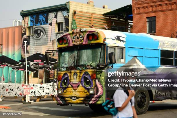 The school bus being spray-painted in the street at 27th St. And Larimer St. For the street art festival "Crush Walls" at River North Art district of...