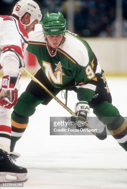 Mike Modano of the Minnesota North Stars faces off against Laurie Boschman of the New Jersey Devils during an NHL Hockey game circa 1990 at the...