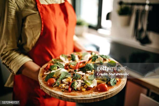 women holding homemade pizza, preparing for cooking - crucifers stock pictures, royalty-free photos & images