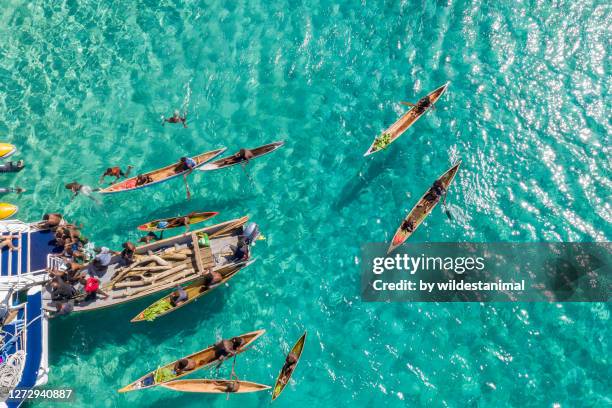 indigenous islanders selling produce and souvenirs to tourists on a dive boat, kimbe bay area, papua new guinea. - papua new guinea people stock pictures, royalty-free photos & images