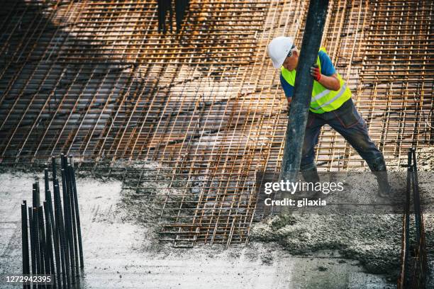 het pompen van beton over rebargaas. - concrete building stockfoto's en -beelden