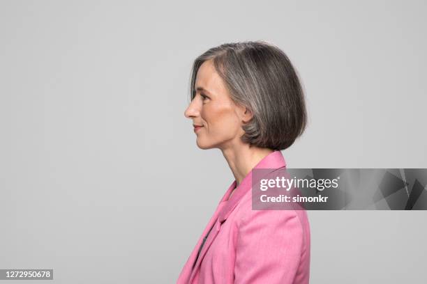 side view of smiling mature woman - pink jacket stock pictures, royalty-free photos & images