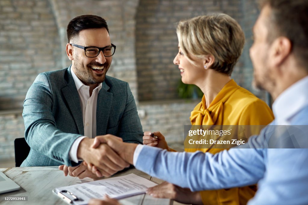 Happy insurance agent came to an agreement with a couple in the office.