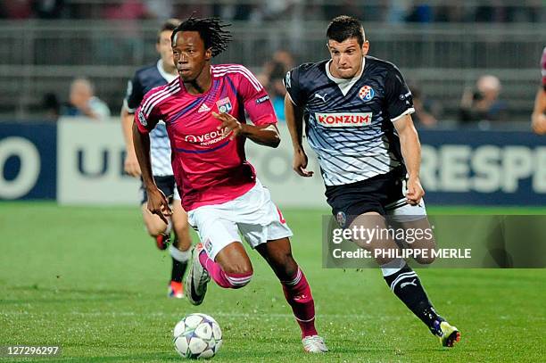 Lyon's Burkinabe defender Bakary Koné vies with Dinamo Zagreb's forward Fatos Beqiraj during the Champions League football match Lyon vs Dinamo...