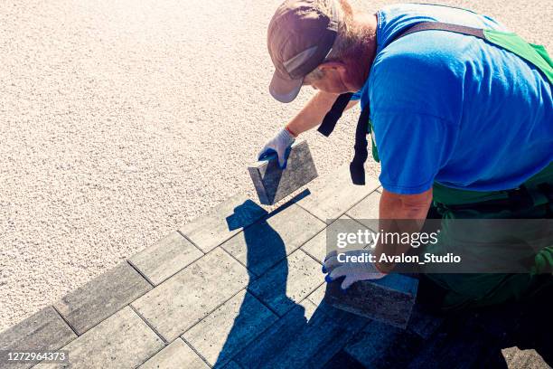 paver aan het werk - block paving stockfoto's en -beelden