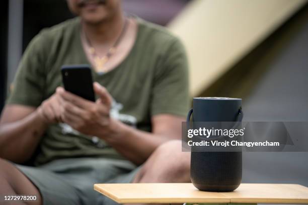 black portable speaker with middle aged man blur background - bluetooth stock-fotos und bilder