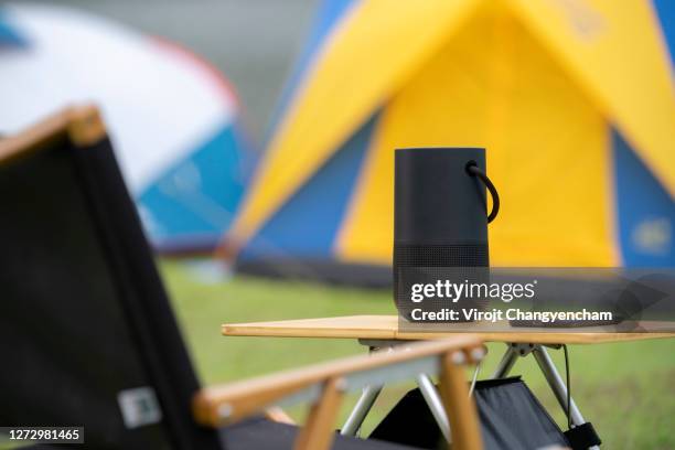 black portable speaker on the outdoor table - bluetooth speaker stock-fotos und bilder