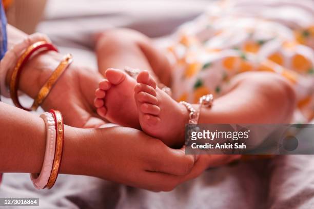 close up mother holding feet of baby in her hand - son massage mom imagens e fotografias de stock