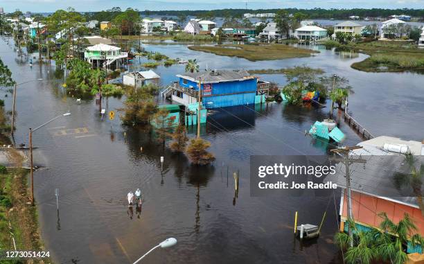 An aerial view from a drone shows people walking through a flooded street after Hurricane Sally passed through the area on September 17, 2020 in Gulf...