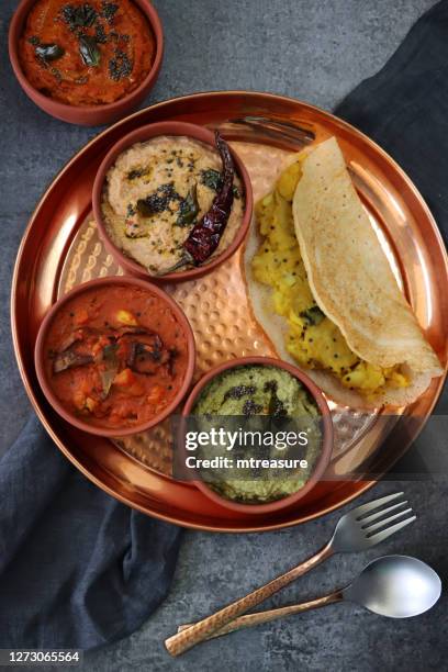 bild von metall tablett von indischen dosa herzhafte pfannkuchen, pfannkuchen krepp gefüllt mit pürierten masala kartoffel, schalen von kokos-chutney, minze und koriander chutney, ingwer, chili und knoblauch dip, und erdnuss-chutney, grauer hintergrund, - chutney stock-fotos und bilder