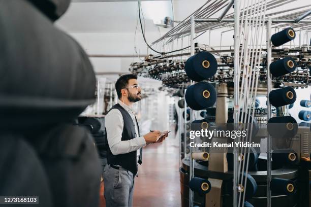 small business-besitzer überprüft die leistung der maschinen - textilindustrie stock-fotos und bilder