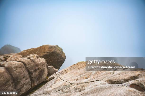 rope for climbing and clouds covering the pico das prateleiras (shelves peak) on top of the mountains of the itatiaia national park (parque nacional do itatiaia) - prateleiras stock-fotos und bilder