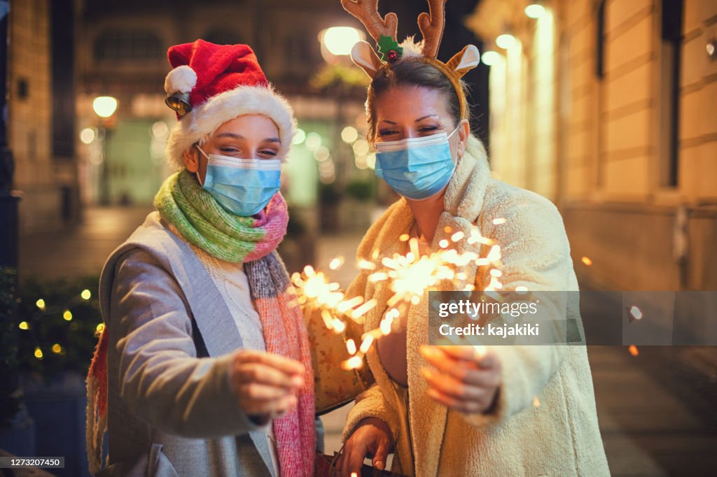 Family having fun while celebrating Christmas during COVID-19 pandemic. They wears a protective mask to protect from coronavirus COVID-19.