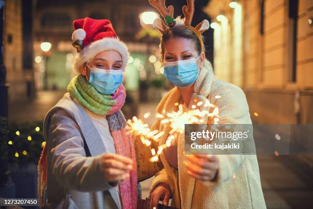 family having fun while celebrating christmas during covid-19 pandemic. they wears a protective mask to protect from coronavirus covid-19. - happy new year 2021 stock pictures, royalty-free photos & images
