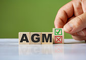 The hand turn wooden block with red reject X and green confirm tick as change concept of AGM. Word AGM conceptual symbol