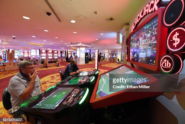 Jim Massalone and Randy Czekaj, both of Florida, play a video blackjack machine at the Tropicana Las Vegas after the Las Vegas Strip resort reopened...