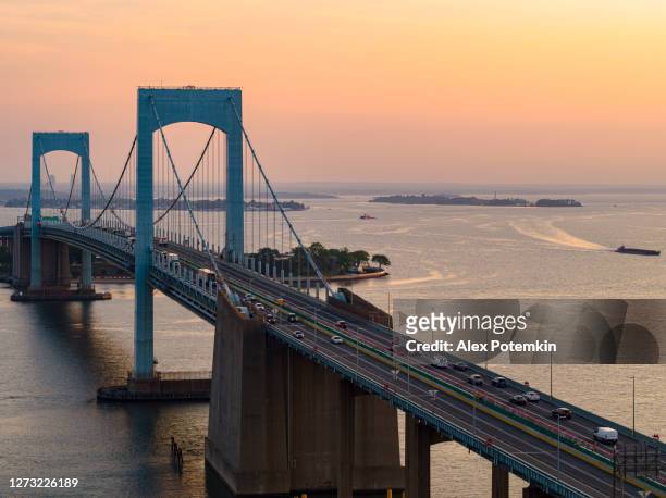 mäßiger verkehr auf der throgs neck bridge über den east river, der queens und bronx boroughs, new york, bei sonnenaufgang verbindet. - bronx stock-fotos und bilder