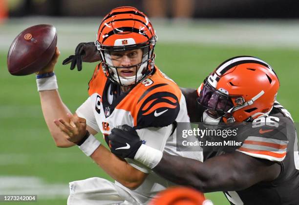 Joe Burrow of the Cincinnati Bengals is wrapped up by Vincent Taylor of the Cleveland Browns during the second half at FirstEnergy Stadium on...