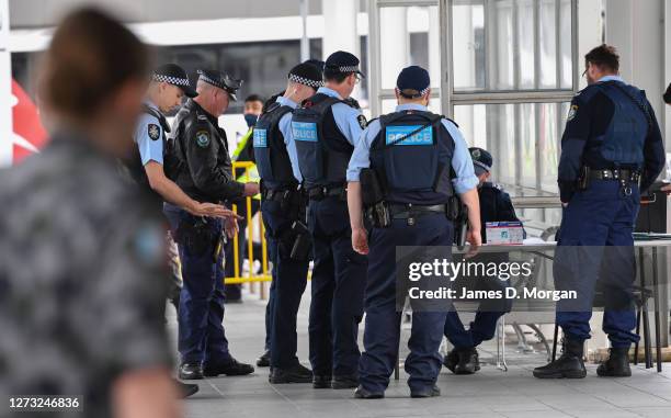 Australian Federal Police wait for passengers to arrive at Sydney International Airport on September 18, 2020 in Sydney, Australia. Arrival caps will...