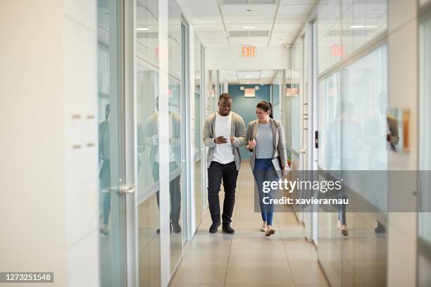 diverse business partners walking in miami coworking office - come & get it stock pictures, royalty-free photos & images