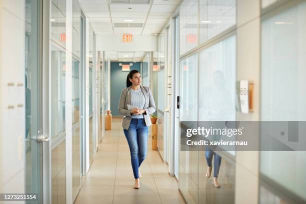 unga spansktalande affärskvinna walking i coworking office - approaching bildbanksfoton och bilder