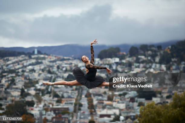 ballet dancer practicing in city against sky - ballett stock-fotos und bilder