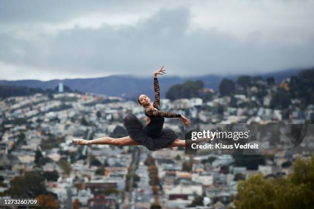 ballet dancer practicing in city against sky - urban ballet stockfoto's en -beelden