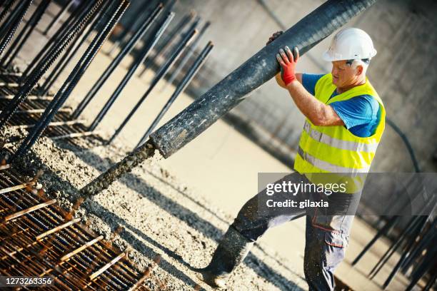 pumping concrete over rebar mesh. - reinforced concrete stock pictures, royalty-free photos & images