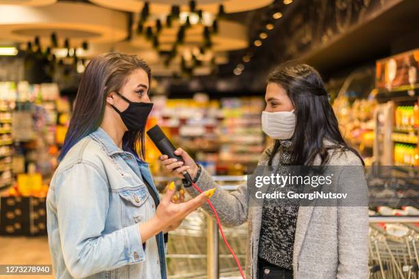 a reporter for a news channel interviewed a woman in a mall. covid 19 - tv reporter street stock pictures, royalty-free photos & images