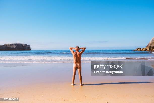 mid adult  man naked on a nudist beach, beach of torimbia, asturias, northern spain - beach bum fotografías e imágenes de stock