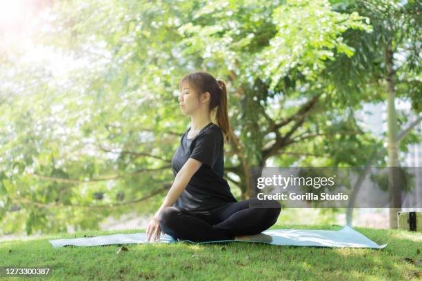 yong girl doing yoga stretching at outdoors park to release stress and anxiety - chan yong park stock pictures, royalty-free photos & images