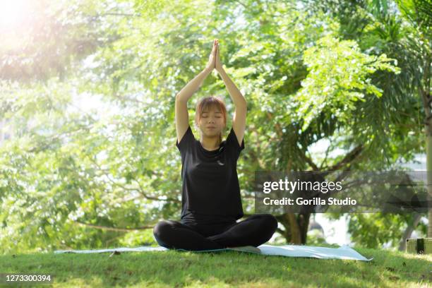 yong girl doing yoga breathing at outdoors park to release stress and anxiety - chan yong park stock pictures, royalty-free photos & images