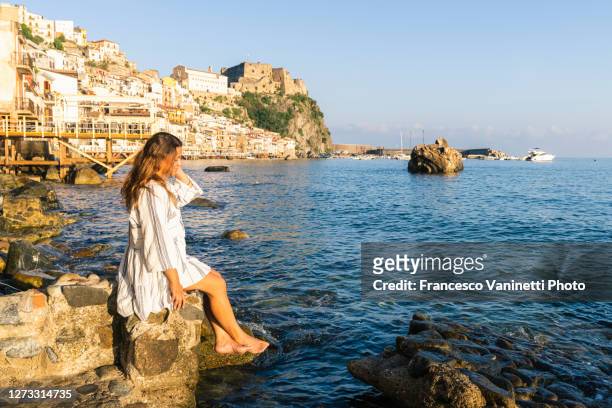 woman relaxing in chianalea, scilla, italy. - reggio calabria italy stock pictures, royalty-free photos & images