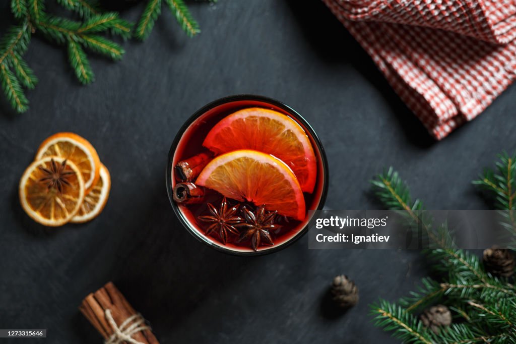 Ein Glas gefüllt mit Glühwein mit Orangenscheiben