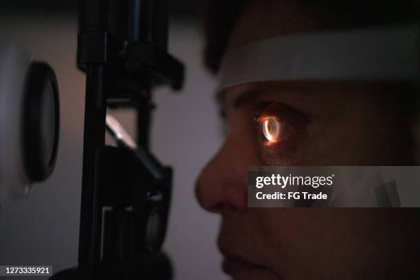 mature woman doing an eye test - retinal scan stock pictures, royalty-free photos & images