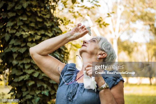 senior woman putting eye drop - eyedropper stock pictures, royalty-free photos & images