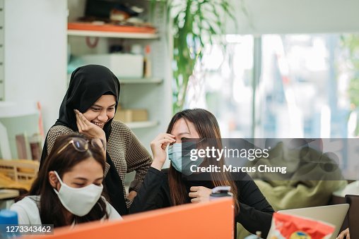Asian malay smiling hijap female having fun with her classmate in college classroom Asian malay smiling hijap female having fun with her classmate in college classroom
