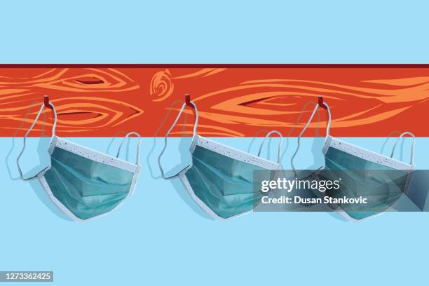face protective masks hanging on a coat rack - back to school covid stock illustrations