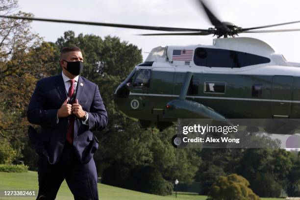 Secret Service agent stands guard as Marine One, with U.S. President Donald Trump aboard, takes off from the South Lawn of the White House September...