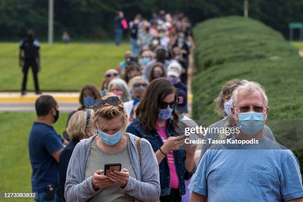 People stand on line, spaced six apart due to COVID-19, in order to vote early at the Fairfax Government Center on September 18, 2020 in Fairfax,...