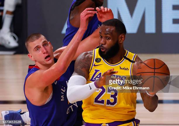 LeBron James of the Los Angeles Lakers passes against Nikola Jokic of the Denver Nuggets during the third quarter in Game One of the Western...